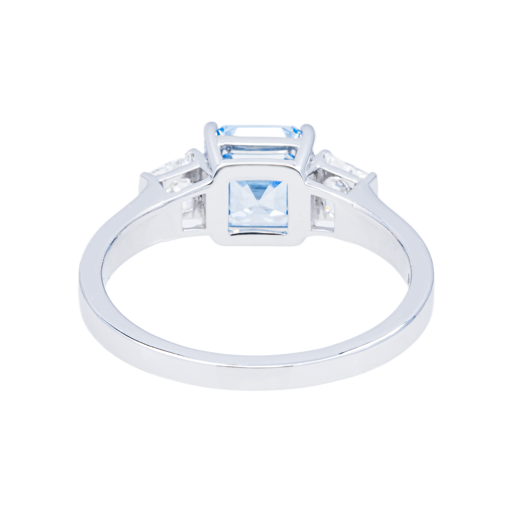 14K white gold fancy blue Asscher cut diamond ring featuring a sparkling blue gemstone and intricate band design.