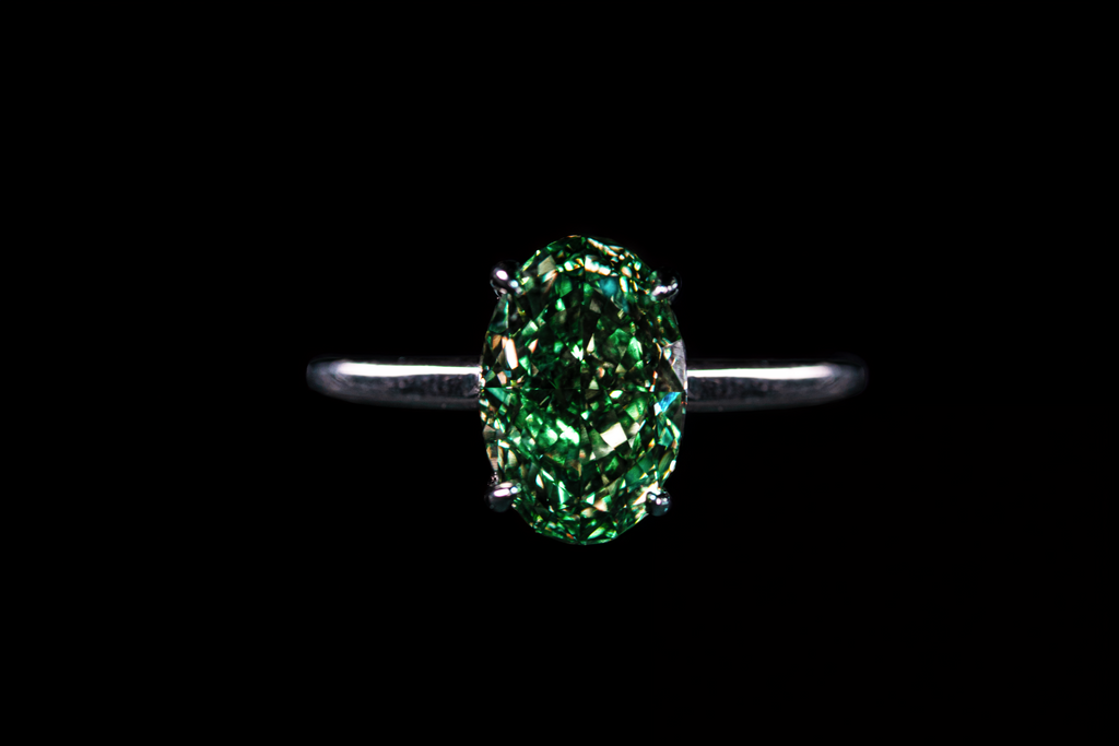14K white gold solitaire oval ring with a 3.25-carat fancy green diamond, showcasing elegant jewelry craftsmanship.